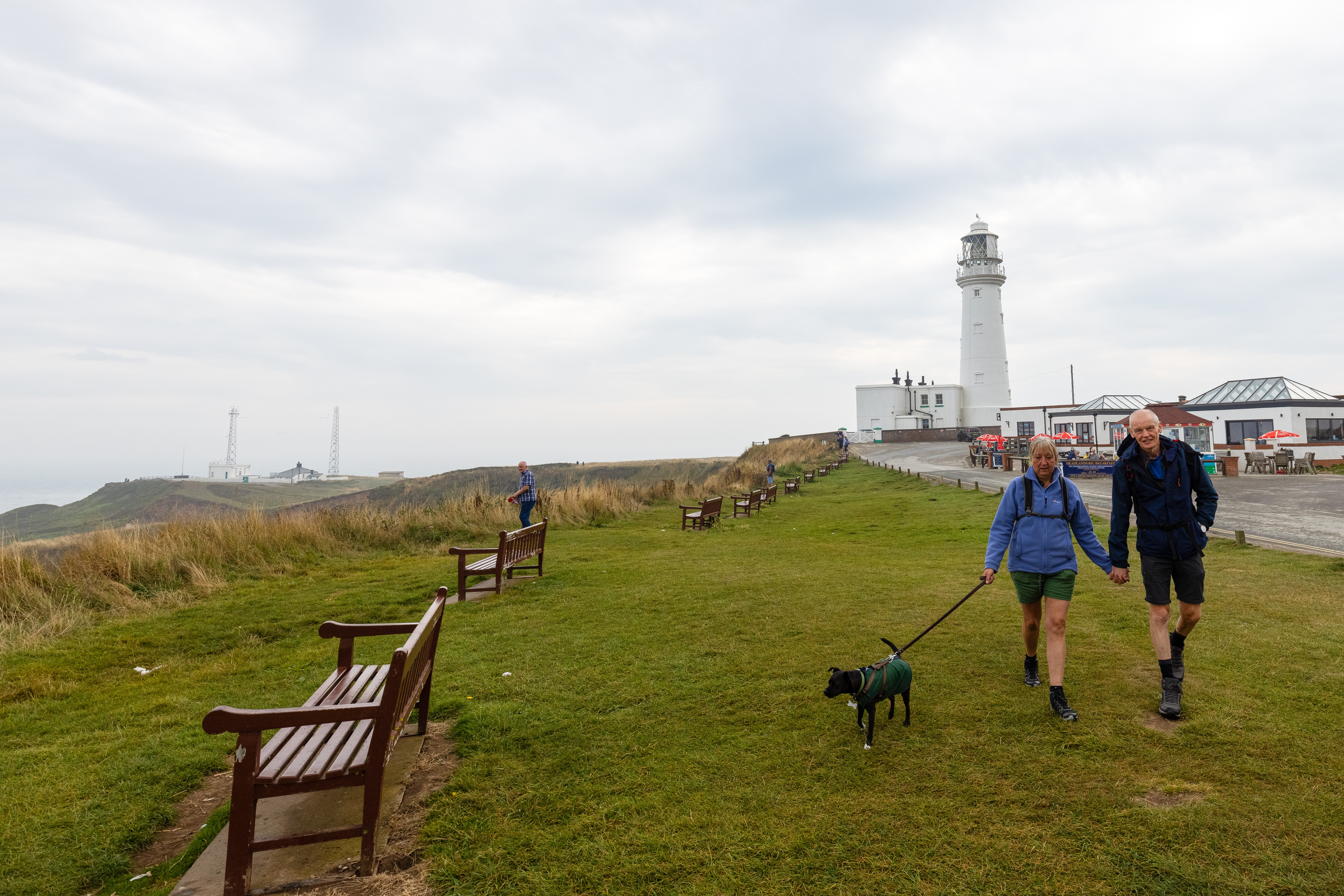 Couple in Flamborough with dog and lighthouse in the background