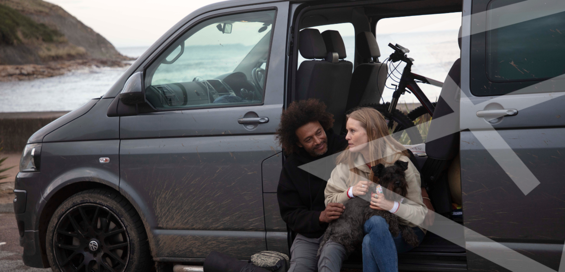 Picture of couple and dog sat by a camper van in Scarborough.